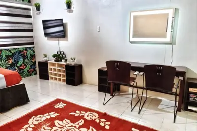 a bedroom with a desk and two chairs and a bed at CENTROPOLIS 3, Tropical Modern in Manila