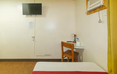 a room with a table and a chair and a shower at RedDoorz near EDSA Camp Crame in Manila