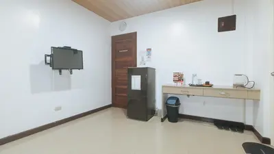 a room with a refrigerator and a desk in it at RedDoorz at RJs Bldg near Lyceum Gen Trias Cavite Cion Suites in General Trias