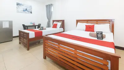 two beds with red and white sheets in a room at RedDoorz at RJs Bldg near Lyceum Gen Trias Cavite Cion Suites in General Trias