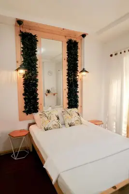 a bedroom with a large white bed with plants on the wall at House of Citiflora Unit A in Manila