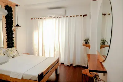 a bedroom with a large bed and a mirror at House of Citiflora Unit A in Manila