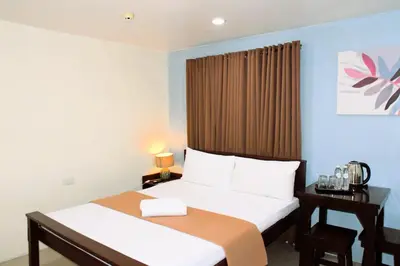 a hotel room with two beds and a window at Arzo Hotel Makati in Manila