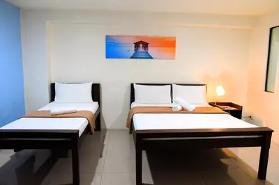 a room with two beds and a painting on the wall at Arzo Hotel Makati in Manila