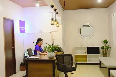 a woman sitting at a desk in an office at Arzo Hotel Makati in Manila