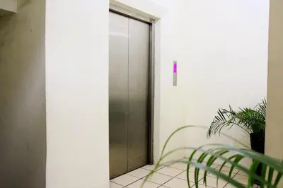 an elevator door in a room with a plant at Arzo Hotel Makati in Manila