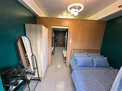 a bedroom with a bed and a green wall at Kathys Crib at Shell Residences in Manila