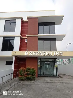 a red and white building with a sign on it at 8 Zhensen Inn in Bacoor