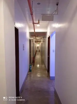 an empty hallway in an office building with white walls at 8 Zhensen Inn in Bacoor