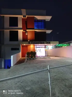 a building at night with a bench in front of it at 8 Zhensen Inn in Bacoor