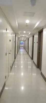 an empty hallway of a building with white floors and walls at Family Suite Staycation FAME Residence 1508 Tower1 in Manila
