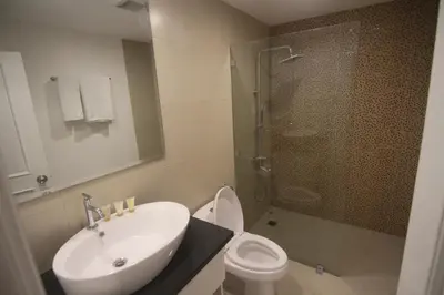 a bathroom with a toilet and a sink and a shower at Bryan Condo Suites Makati near Airport in Manila