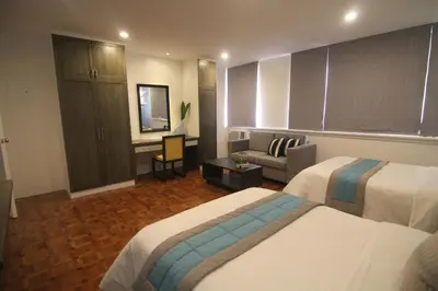 a hotel room with two beds and a couch at Bryan Condo Suites Makati near Airport in Manila