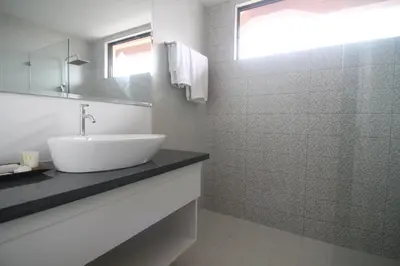 a white bathroom with a sink and a mirror at Bryan Condo Suites Makati near Airport in Manila