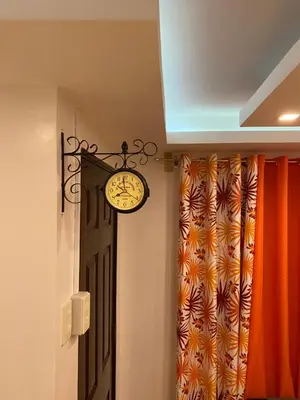 a clock hanging on the wall next to a door at MidKnight Sky Unit for Rent in Anabu Primero