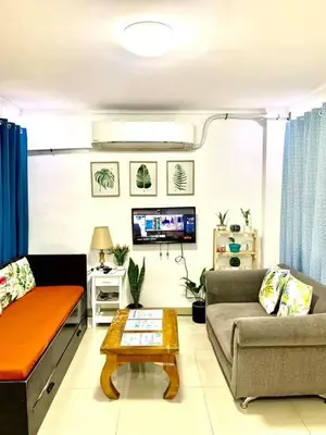 a living room with a couch and a coffee table at Cozy Central - Near arca south signal taguig in Manila