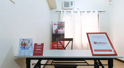 a table with a laptop sitting on top of it at RedDoorz @ Jolly Orange Paranaque in Manila