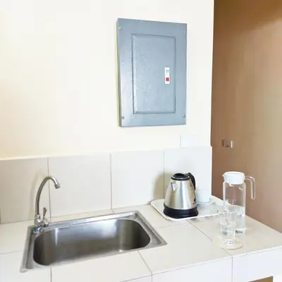 a kitchen with a sink and a kettle on a counter at airobedz MANILA - A Value Hotel in Manila