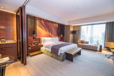 a hotel room with a bed and a desk at Marco Polo Ortigas Manila in Manila