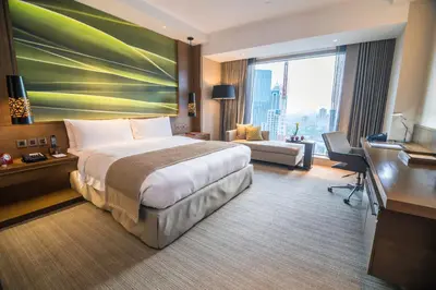 a hotel room with a large bed and a desk at Marco Polo Ortigas Manila in Manila