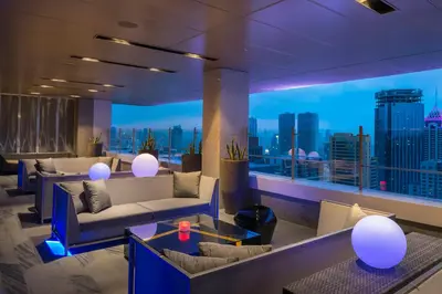 a hotel lobby with couches and a view of a city at Marco Polo Ortigas Manila in Manila