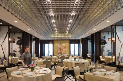 a man standing in front of a dining room with tables at Marco Polo Ortigas Manila in Manila