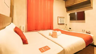 a hotel room with two beds with a book on them at RedDoorz @ Good 101 Quiricada Manila in Manila