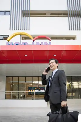 a man in a suit talking on a cell phone at Hop Inn Ortigas Center Manila in Manila