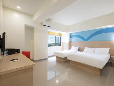 a hotel room with two beds and a desk at Hop Inn Ortigas Center Manila in Manila