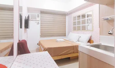 a small room with a bed and a sink at Eimys Place at Urban Deca Mandaluyong by RedDoorz in Manila