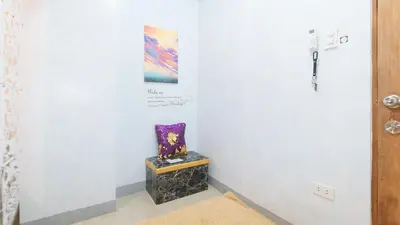 a room with a chair and a painting on the wall at Budget Backpackers Transient House near NAIA by RedDoorz in Manila