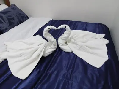 two white swans forming a heart on a bed at Lovely Condo 2-BR w/balcony in SM-Sucat, Paranaque in Manila
