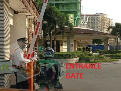 a man on a motorcycle in front of an entrance gate at Paranaque SM-Sucat Field Res. Bldg 5, 2/F, 2BR with Balcony in Manila