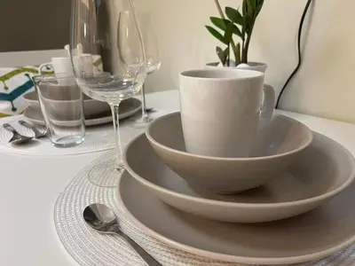 a table with a cup and a plate and wine glasses at MOA staycation Shell Residences Pasay city darpm in Manila