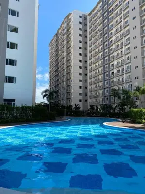 a large swimming pool in front of a large building at A Cozy 1 Bedroom Unit with a Parking at Tower 2 South Residences SM Southmall in Manila