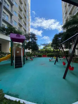 an empty playground with a slide and swings at A Cozy 1 Bedroom Unit with a Parking at Tower 2 South Residences SM Southmall in Manila