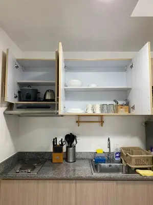 a kitchen with white cabinets and a sink and a counter at A Cozy 2 Bedroom Unit with a Parking at Tower 2 South Residences SM Southmall in Manila