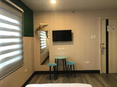 a room with two stools and a tv on the wall at Maine City Residences Leveriza in Manila