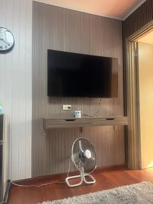 a living room with a fan and a flat screen tv at FRD Condo Unit Tower A SoleMare Parksuites in Manila