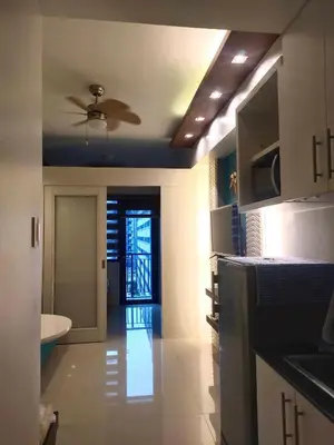 a kitchen with a ceiling fan and a kitchen with a sink at Moa's Spot at Sea Residences in Manila