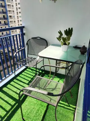 a table and chairs on a balcony with a table at Moa's Spot at Sea Residences in Manila