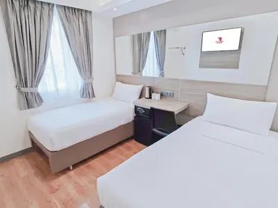 a hotel room with two beds and a desk at Red Planet Ortigas in Manila