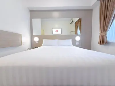 a bedroom with a large white bed and a window at Red Planet Ortigas in Manila