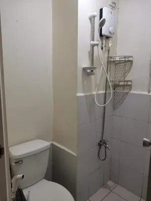 a bathroom with a shower with a toilet and a sink at Mack's Awesome Place 11 with Netflix and FastUnliwifi in Manila