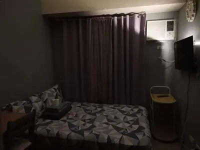 a bedroom with a bed in front of a window at Mack's Awesome Place 11 with Netflix and FastUnliwifi in Manila