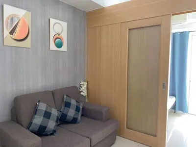 a living room with a brown couch and a door at SHELL RESIDENCE C6 shortwalk MALL OF ASIA in Manila