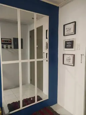 a room with a large mirror on a blue wall at Chichi's Snug Pad near Enchanted Kingdom and Nuvali in Santa Rosa