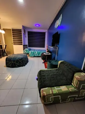 a living room with two couches and a blue wall at Chichi's Snug Pad near Enchanted Kingdom and Nuvali in Santa Rosa