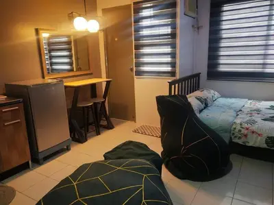 a bedroom with a bed and a kitchen with a table at Chichi's Snug Pad near Enchanted Kingdom and Nuvali in Santa Rosa
