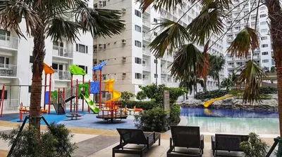 a playground in the middle of a building with palm trees at SHELL RESIDENCE c4 shortwalk Mall of Asia near airport in Manila